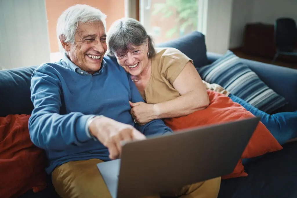 Elderly couple on couch laughing