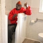 A delighted man in a red shirt enjoying his step-through tub after winning a free bathroom remodel giveaway.