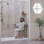 Elderly woman sitting comfortably in her new walk-in shower after bath safety services with Atlas Home Safety