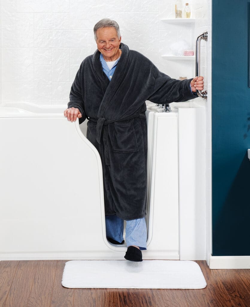 Man in gray robe exiting a walk-in tub shower combo