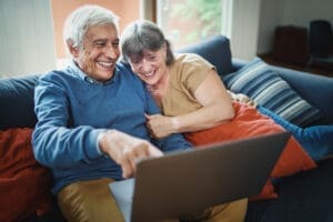 Elderly couple on couch laughing