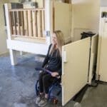 Lady in a wheelchair about to use a vertical platform lift